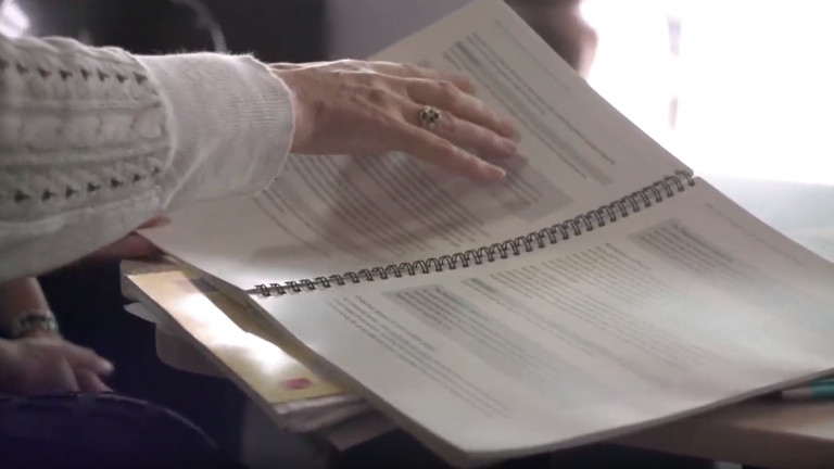 A woman's hand pointing at a part of the Official Information Act guidance provided by the Ombudsman.